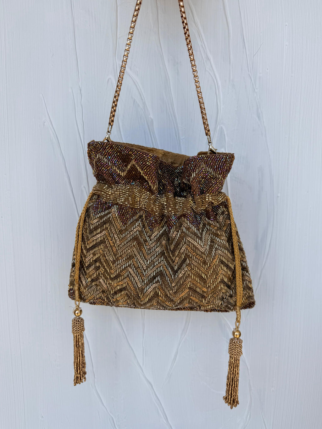 Gold bronze Indian Potli bag with chevron beading and tassel detail